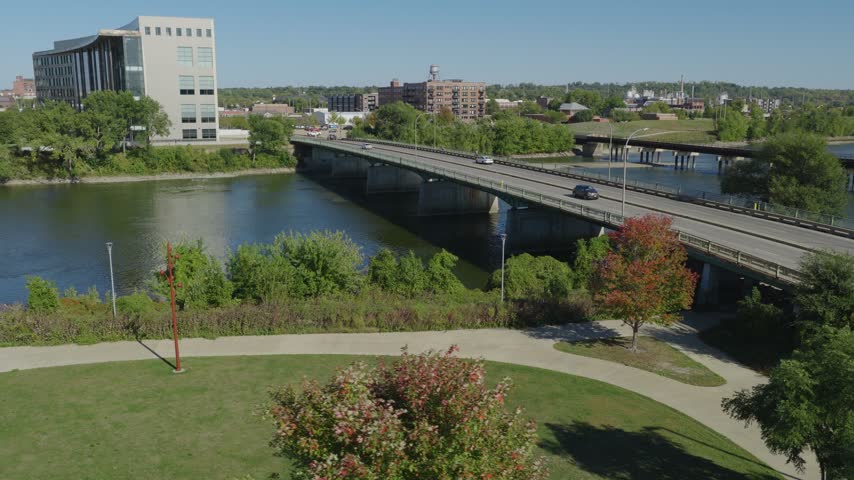 Cedar River bridge beside landscaped riverfront park in Cedar Rapids, Iowa, aerial