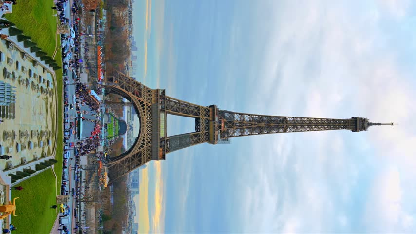 Stunning view of iconic Eiffel tower in Paris France at sunset featuring bustling city streets and historic architecture.