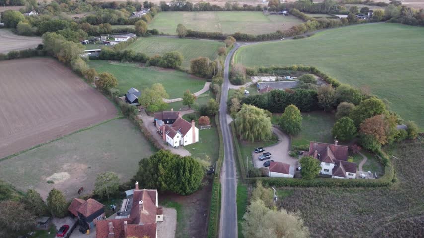 Aerial view of luxury rural Essex houses flying sideways panning and descending