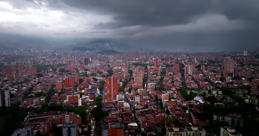 Urban cityscape with dense neighborhoods in valley of Medellin, Colombia. Aerial forward