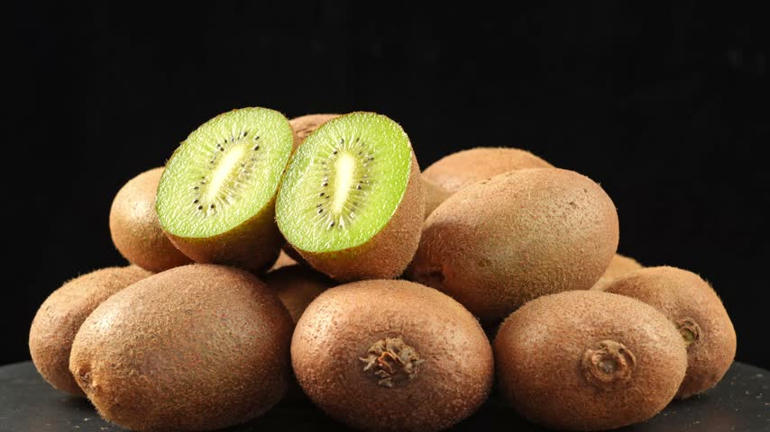 Fresh Sliced Kiwis with Whole Fruits in Background	