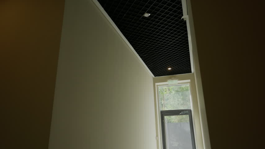 Narrow residential corridor with grid ceiling and window