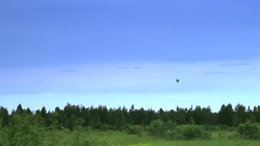 Hot air balloon landing in blue sky time-lapse