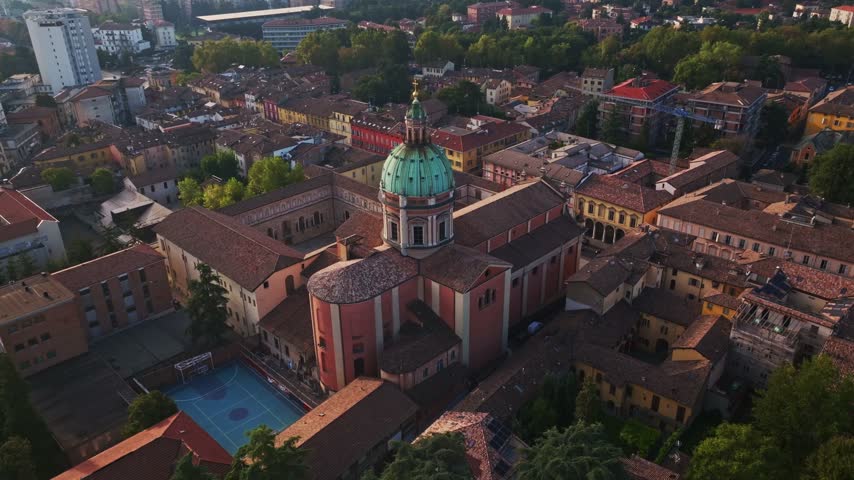 Aerial drone view of Parrocchia di San Pietro in Reggio Emilia, Italy, showcasing the historic church, elegant architecture, bell tower, rooftops, and surrounding cityscape.