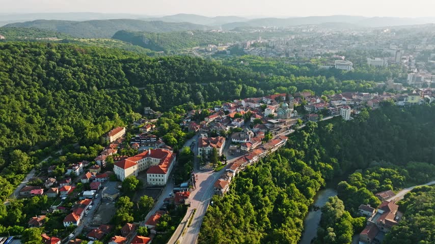 Veliko Tarnovo old town aerial view red tiled roofs houses Yantra river valley sunset historical travel destination Bulgaria stock footage