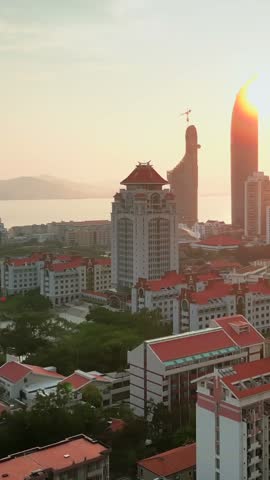 Stunning modern architectural complex of Xiamen University, nestled by the sea, bathed in the warm glow of sunset, exuding vitality and charm.