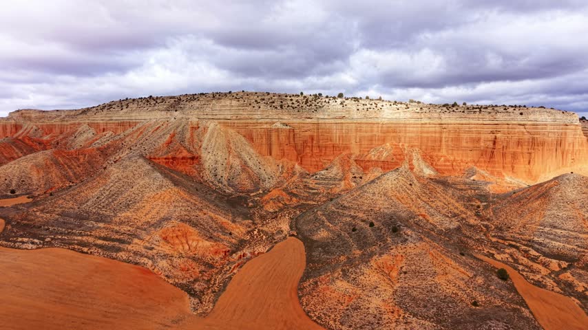 Stunning view of colorful rock formations and layered cliffs in desert landscape. Various rock formations and cliffs in a desert setting under a cloudy sky.