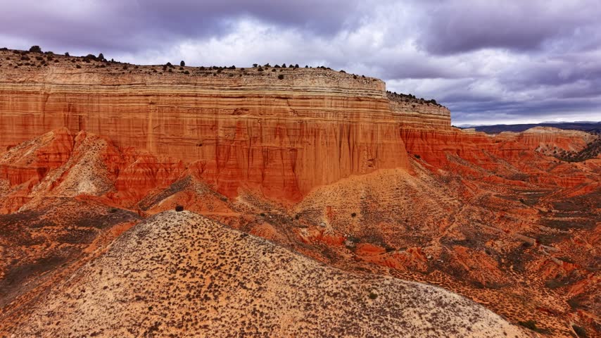 Beautiful landscape showing red rock formations and cloudy sky in a desert area. The scene shows large red rock formations and desert terrain under a cloudy sky.