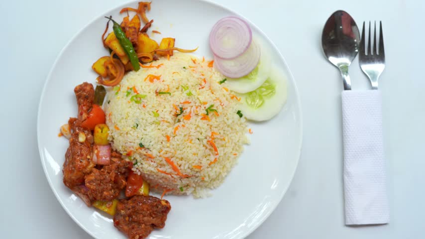 Overhead Fried Rice Meal with Spicy Chicken and Vegetable Sides on White Plate.