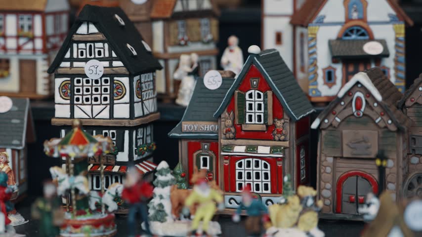 A row of small houses with a red roof and white trim on Christmas market in Germany. The houses are arranged in a line and are all different sizes