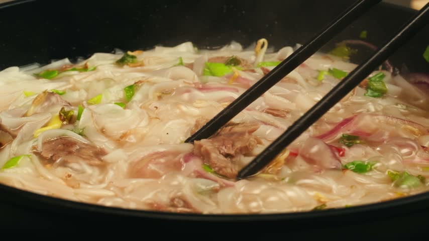 Vietnam traditional pho bo soup on delivery, Beef noodles. Pho Bo Soup with beef, rice noodles, ginger, lime, chili pepper in bowl. Vietnamese cuisine. Pho Noodle Soup restaurant Close-up.