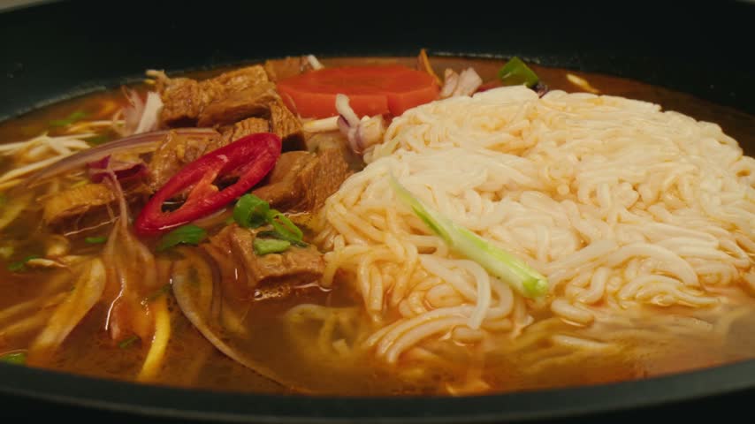 Vietnam traditional pho bo soup on delivery, Beef noodles. Pho Bo Soup with beef, rice noodles, ginger, lime, chili pepper in bowl. Vietnamese cuisine. Pho Noodle Soup restaurant Close-up.