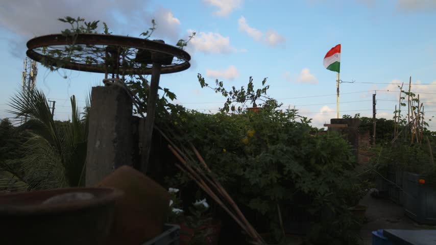 Indian national flag above a rooftop garden with a shaded terrace structure