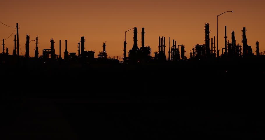 Silhouetted sunset view of a petroleum refinery in Wilmington, California, USA.
