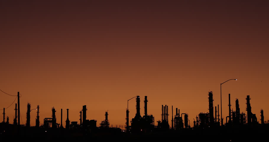 Silhouetted sunset view of a petroleum refinery in Wilmington, California, USA.