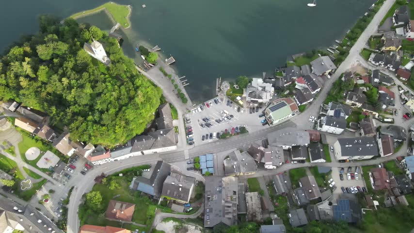 Top down drone view over houses, streets, and green roofs in an Austrian village.