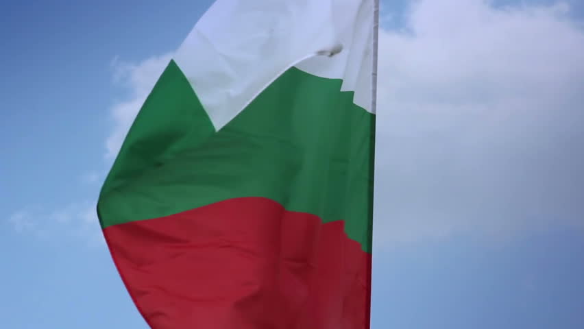 Bulgarian national flag waving on flagpole in blue sky. Bulgaria