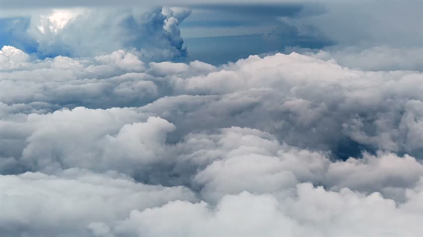 Clouds fill the sky above a blue horizon in this aerial view