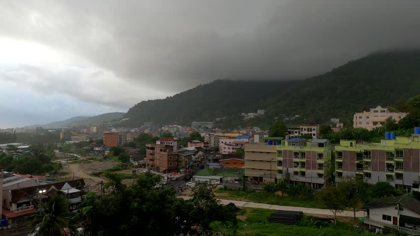 Tropical Mountain City Under Dark Storm Clouds.
