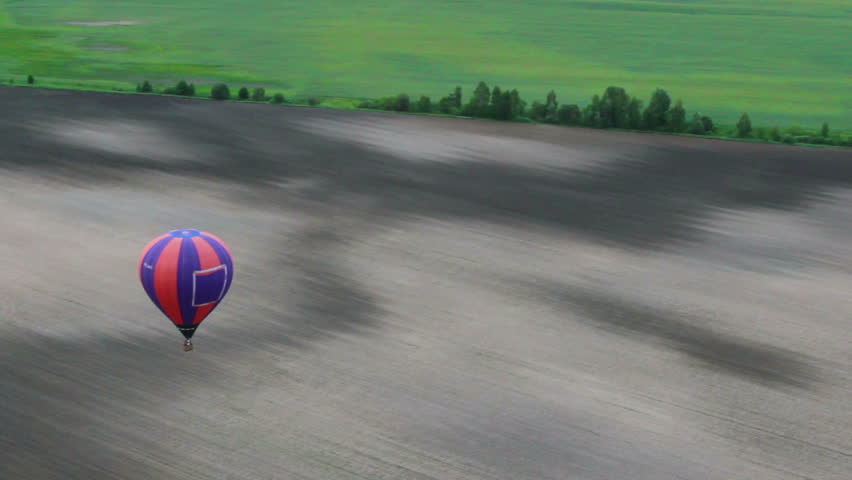 Inside of air balloon pov, smooth motion aerial countryside view over fields