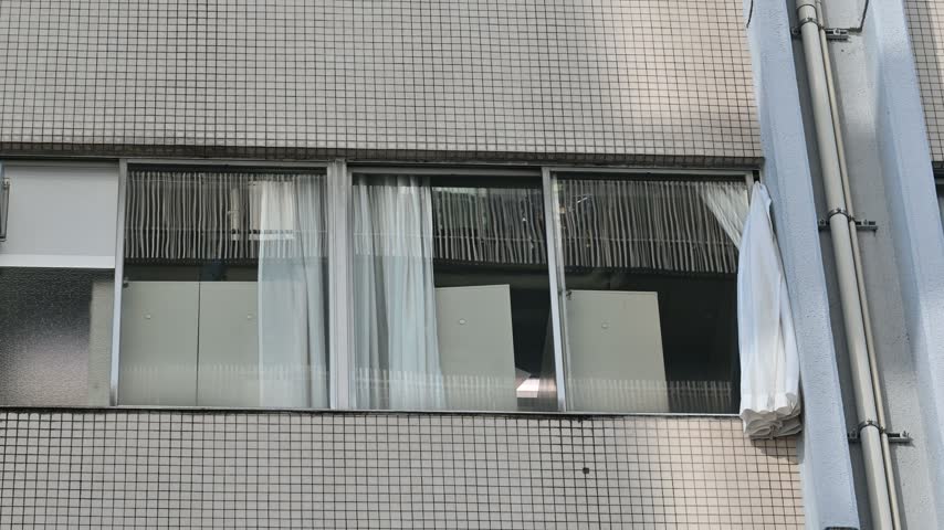 Exterior view of an old commercial building with tiled walls and windows in Tokyo.