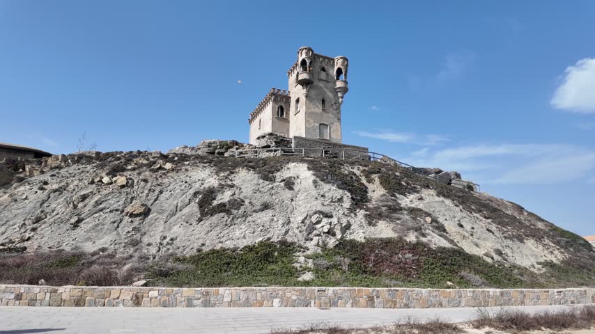 Historic coastal watchtower on a hill at Tarifa beach in Spain