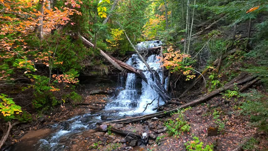Scenic Wagner falls cascading down rocks and a stream flowing through a lush autumn forest  near Munising, Michigan.