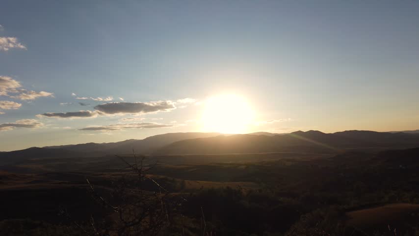 Rear view of long haired man watching sunset in mountains