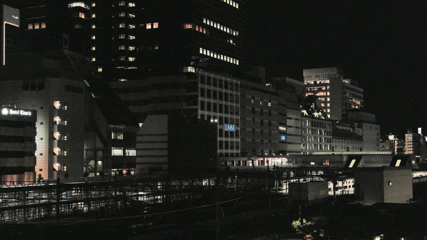 Night in Tokyo  :  Glow of a Commuter Train Heading Home Beneath Urban High-Rise Lights  |  Ikebukuro Station, Tokyo, Japan