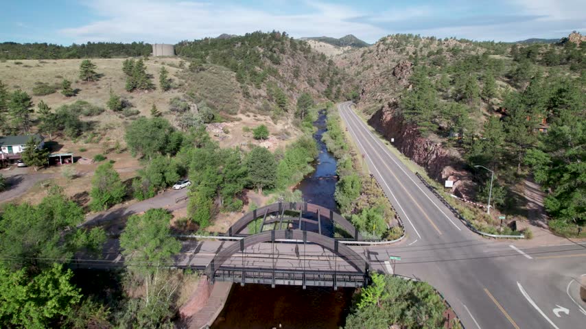 Aerial video of the north saint vrain creek at Apple Valley rd. Camera flies over a bridge.