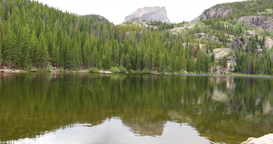 Static video of Bear Lake in the Rocky Mountains Nation Park in Colorado. Mountains and forest are seen in the background.