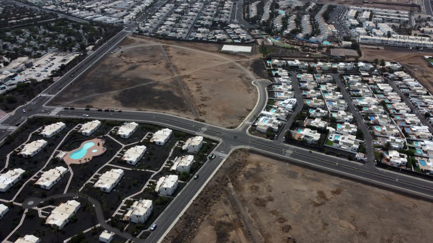 Aerial view of a residential area with roads houses and a large empty lot