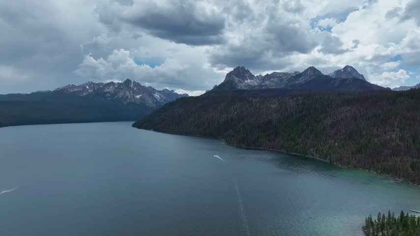 Stanley lake aerial landscape showing watercraft navigating open water near forested shores and jagged peaks