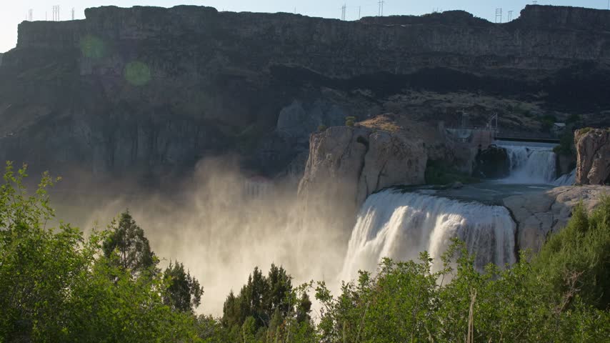 Shoshone falls cascading down rugged rocky cliffs with billowing water mist in scenic river canyon environment