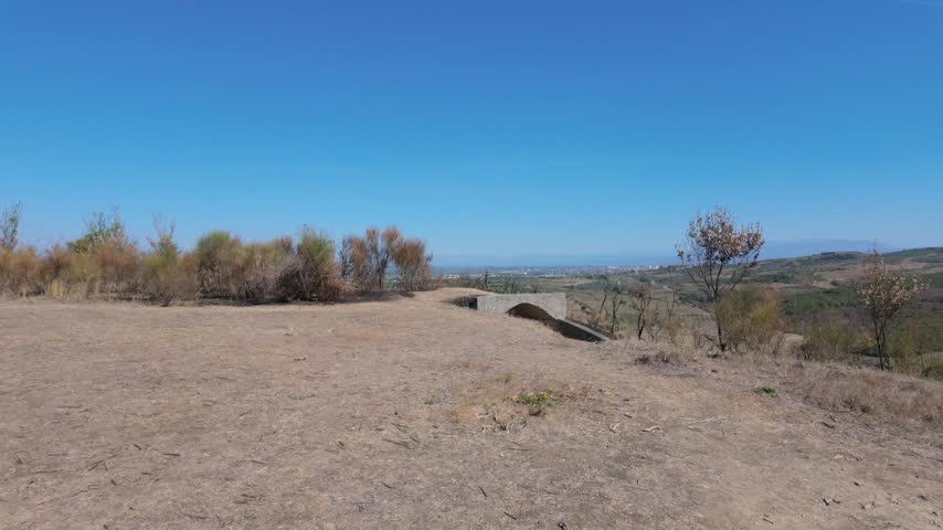 Walking towards a second World War bunker with burned earth nearby