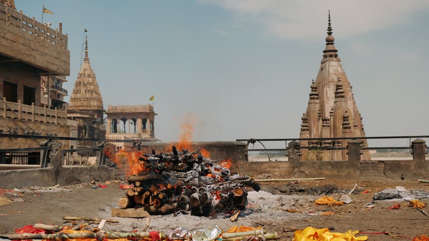 Hindu cremation pyre burning at manikarnika ghat in varanasi, india, along the ganges river.