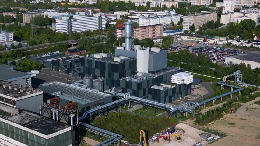Marzahn Combined Cycle Power Plant producing electricity for urban residential areas in Berlin, Germany. Wind turbines visible in the background. Fantastic aerial view static hovering drone panorama