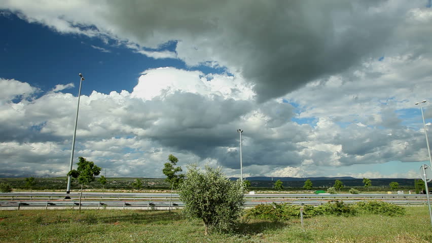 timelapse of clouds over motorway road