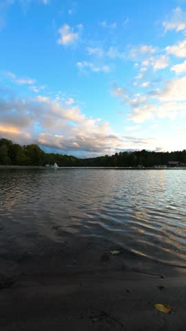 A low lakeside view frames open water beneath pastel clouds and a wooded horizon at Green Lakes State Park in New York.