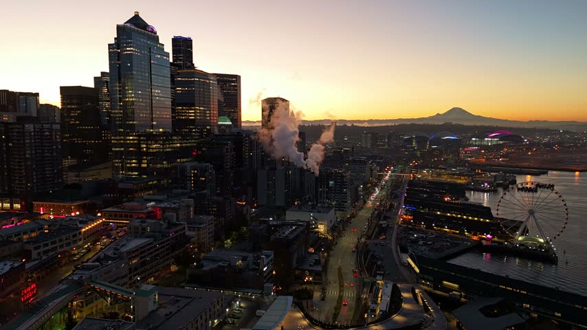 Aerial view of the Seattle skyline at sunset featuring the Great Wheel and Mount Rainier in the background, Seattle, Washington, United States.