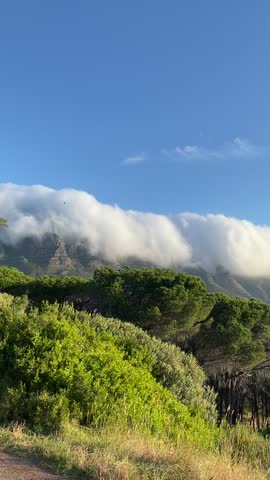 A view of a mountain range from which clouds descend