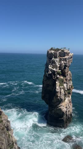 A view of a vertical rock in the ocean on the coast