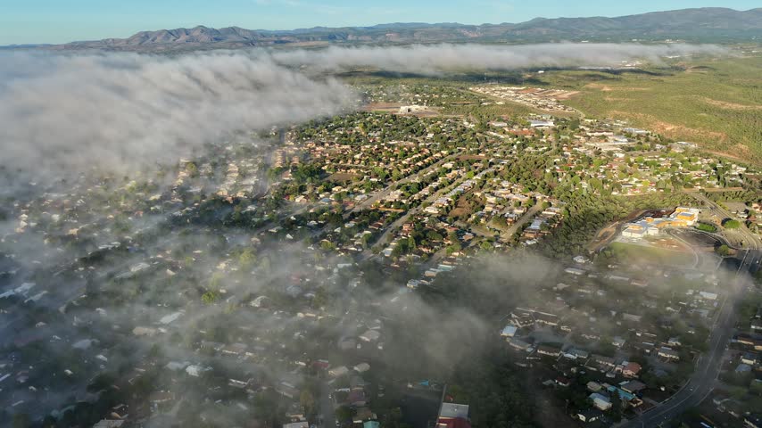 Aerial view of fog rolling over the residential streets and houses of White Rock, New Mexico, United States.