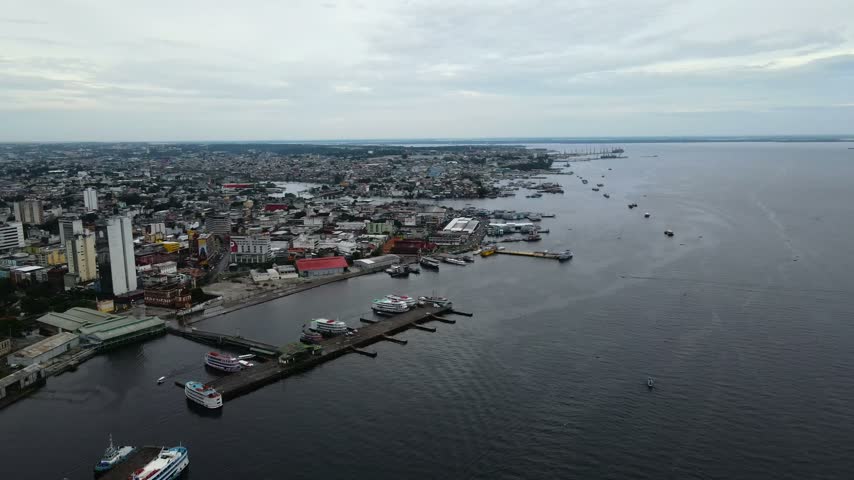 Aerial view of the Manaus waterfront with boats docked at the port and urban buildings along the river, Manaus, Amazonas, Brazil.