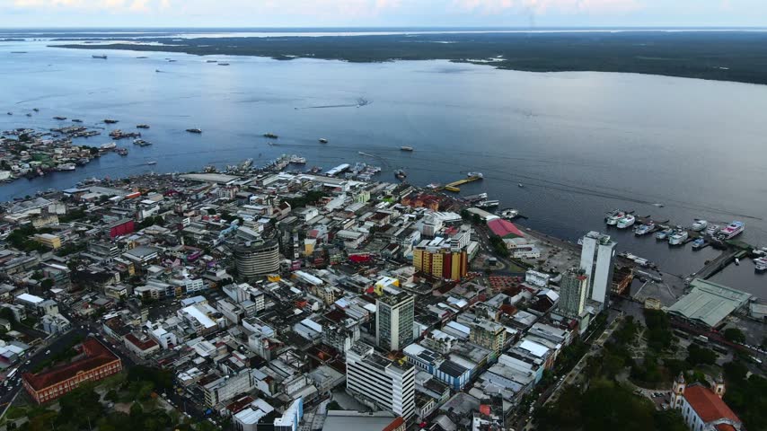 Aerial view of the dense urban landscape of Manaus featuring the busy port area with boats docked along the Rio Negro river in Manaus, Amazonas, Brazil.