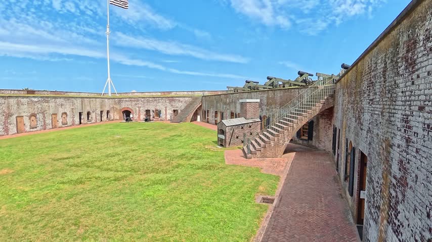 An elevated reveal places artillery in the foreground against a distant coastal horizon.