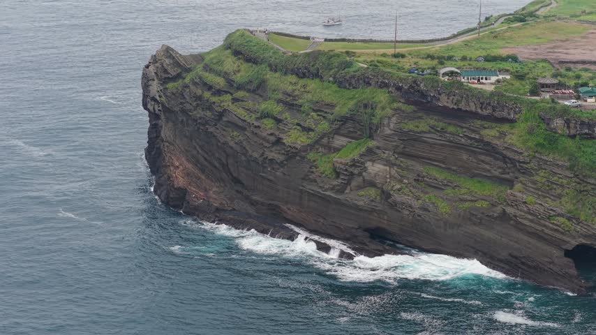 Yongmeori Coast on Jeju Island, South Korea, showing the rugged volcanic coastline, layered rock formations, ocean water and natural coastal landscape