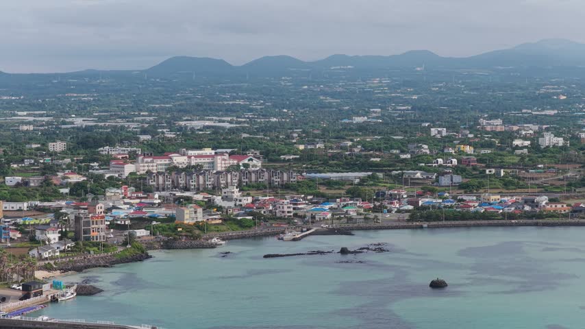 Sinheung-ri on the east coast of Jeju Island, South Korea, showing the coastal landscape, ocean, shoreline and surrounding island scenery - drone shot