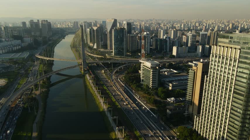 Aerial view of the iconic Octavio Frias de Oliveira cable-stayed bridge spanning the Pinheiros River amidst the modern skyscrapers and busy highways of Sao Paulo, Sao Paulo, Brazil.