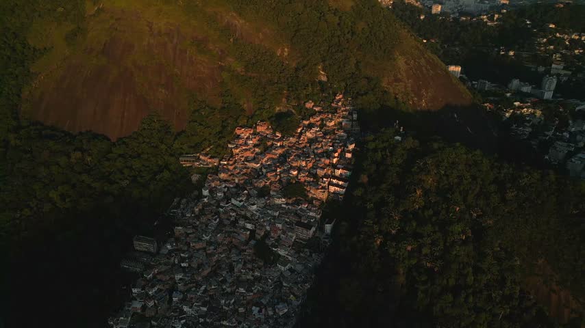 Aerial view of a hillside favela nestled in the lush green slopes of Rio de Janeiro, Brazil.